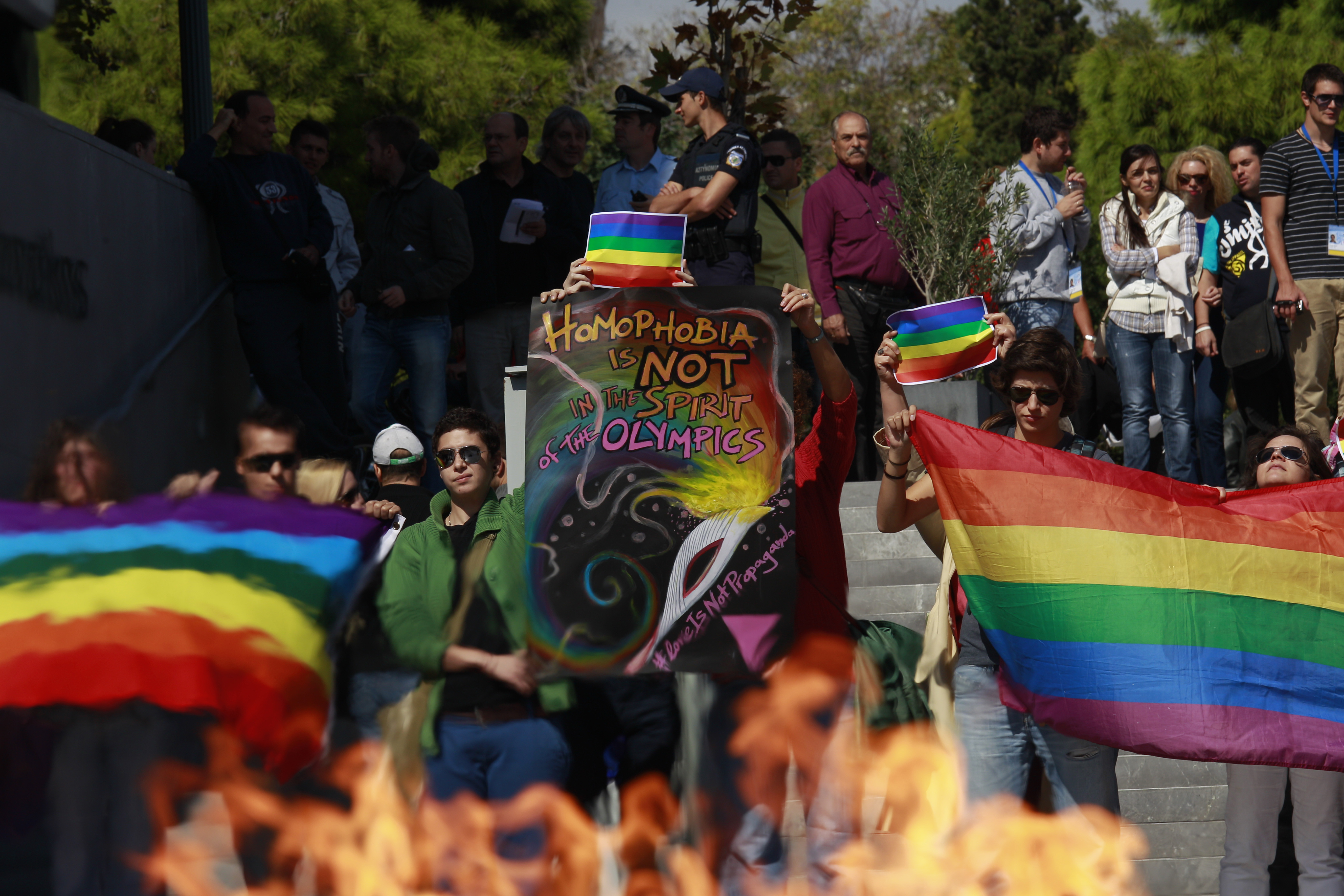 5 October 2013, Greece. LGBT rights activists protest on the steps of the Acropolis museum in Athens while the Olympic flame makes its way through the city.