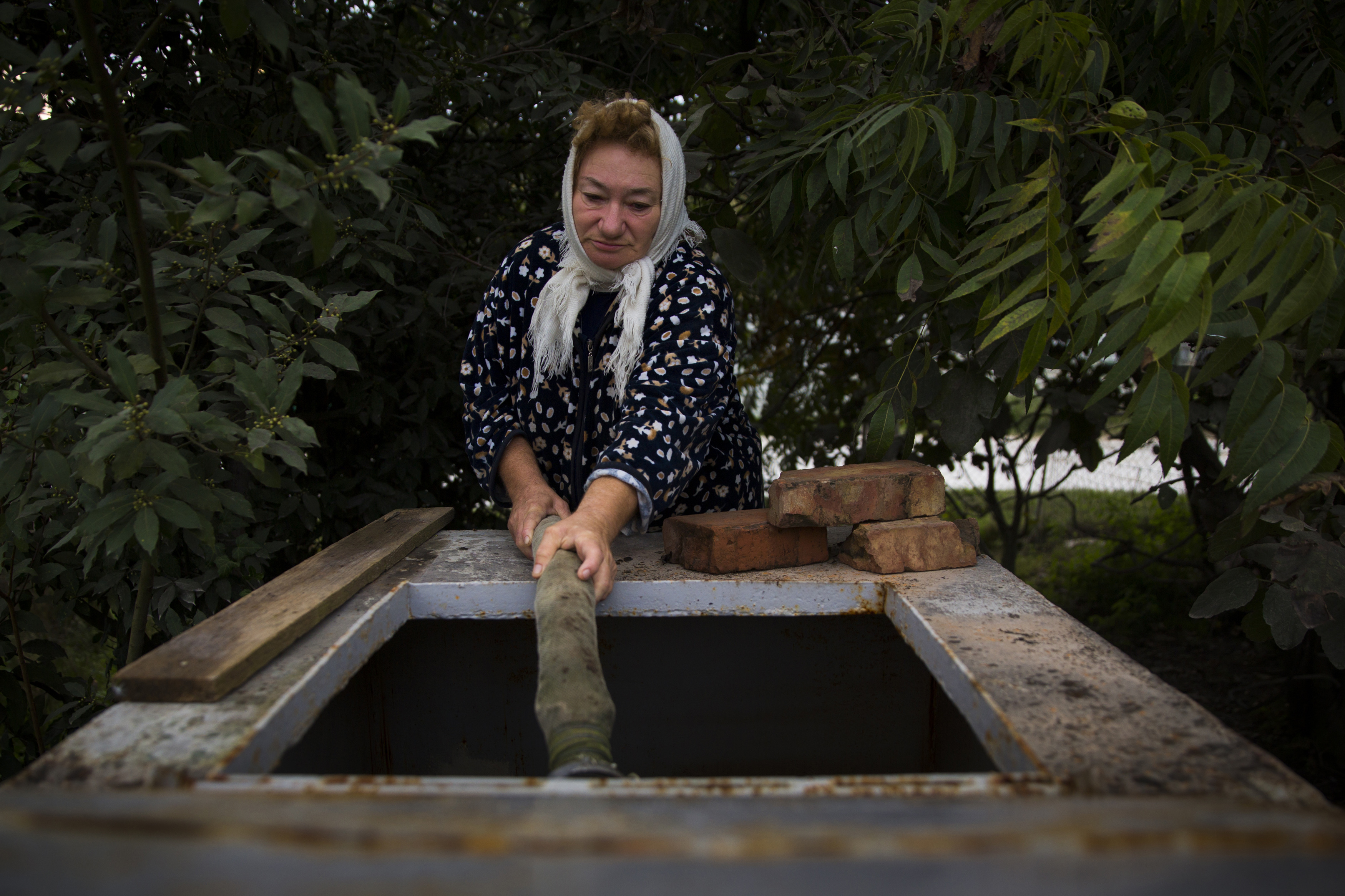 Villager Tatyana Velikaya fills up a tank with her weekly water ration in Akhshtyr, a district of Sochi, 13 October 2013.