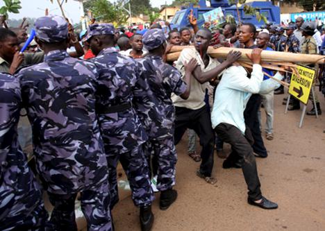 أنصار المعارضة يمرون من أمام رجال الشرطة في كمبالا، أوغندا، 15 شباط 2016