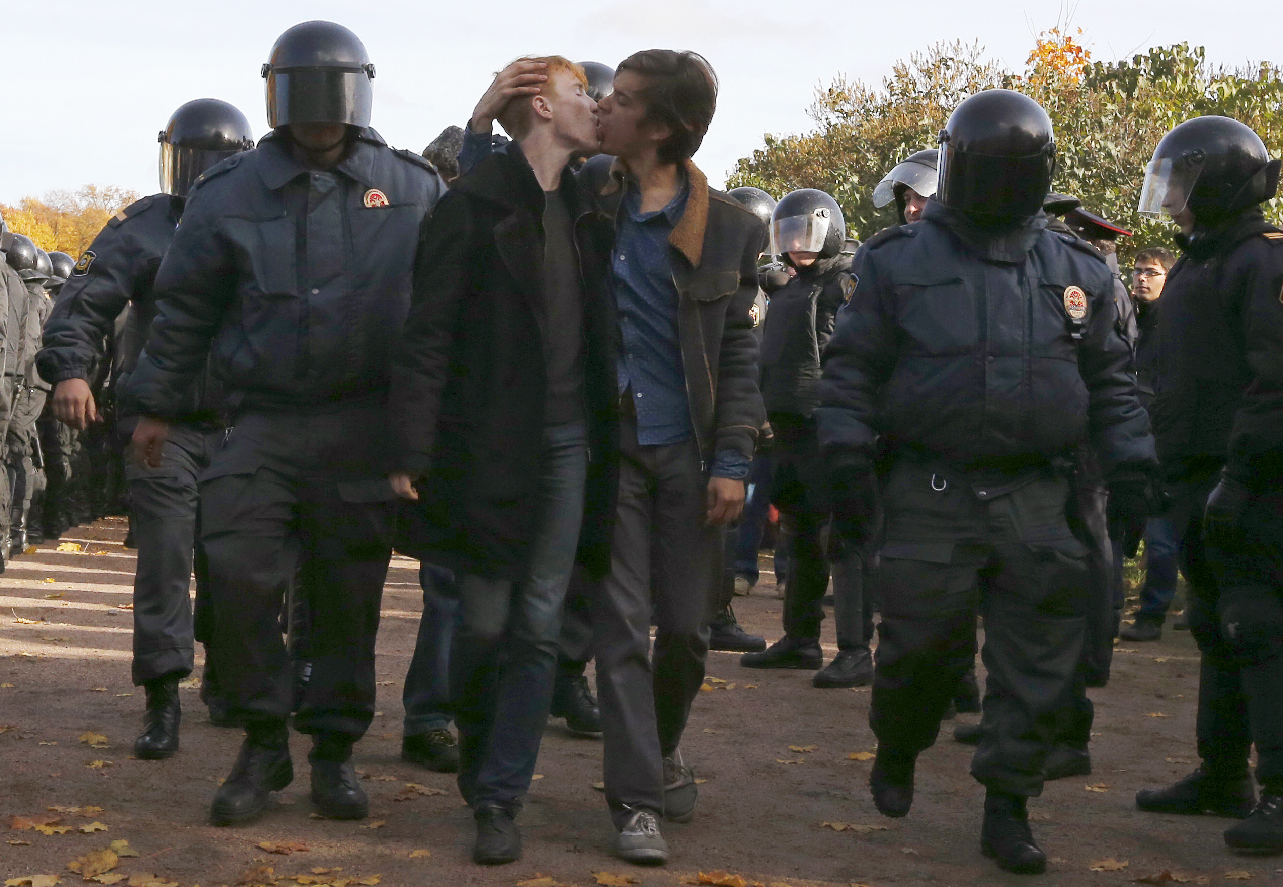 12 October 2013, Russia. LGBT rights activists kiss as they are taken away by police officers during a protest in St. Petersburg.