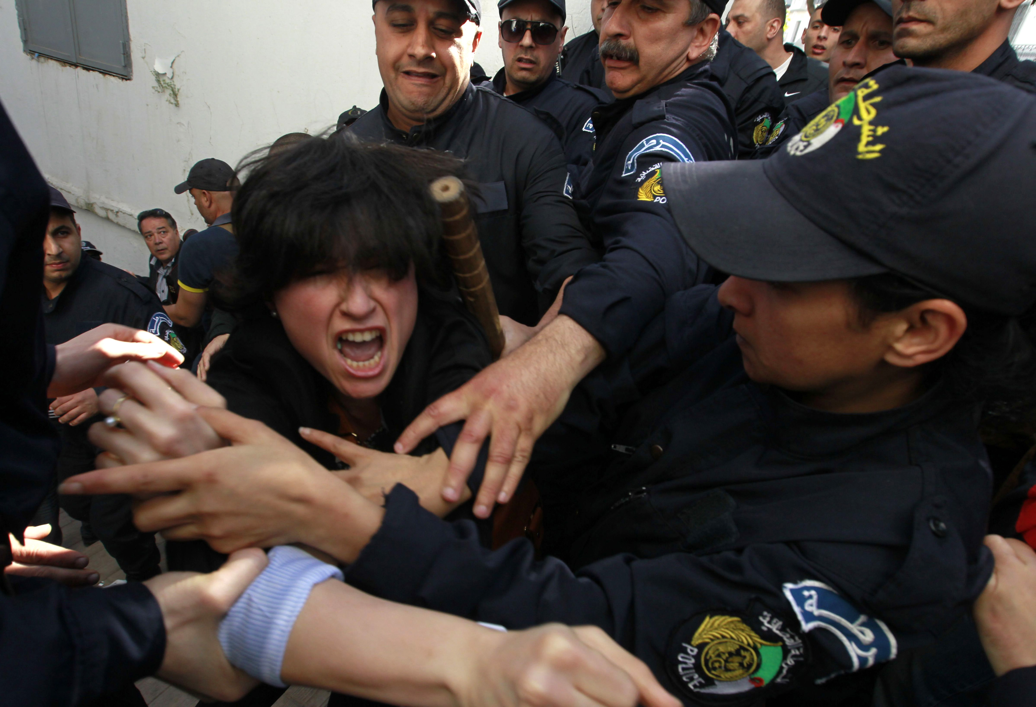 Police officers detain a protester during a demonstration against Algerian President Abdulaziz Bouteflika's decision to run for a fourth term, in Algiers 16 April 2014