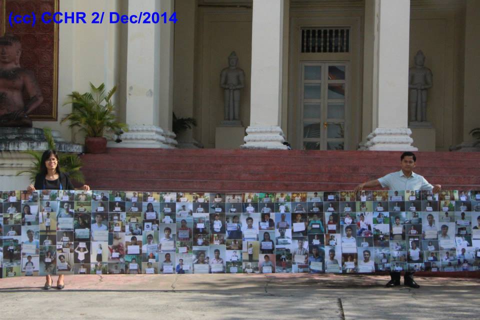المدير التنفيذي تشاك سوبهيب وطاقم مركز كمبوديا لحقوق الإنسان يرفعون الملصقات أمام وزارة العدل، بنوم بنه، 2 كانون الأول 2014
