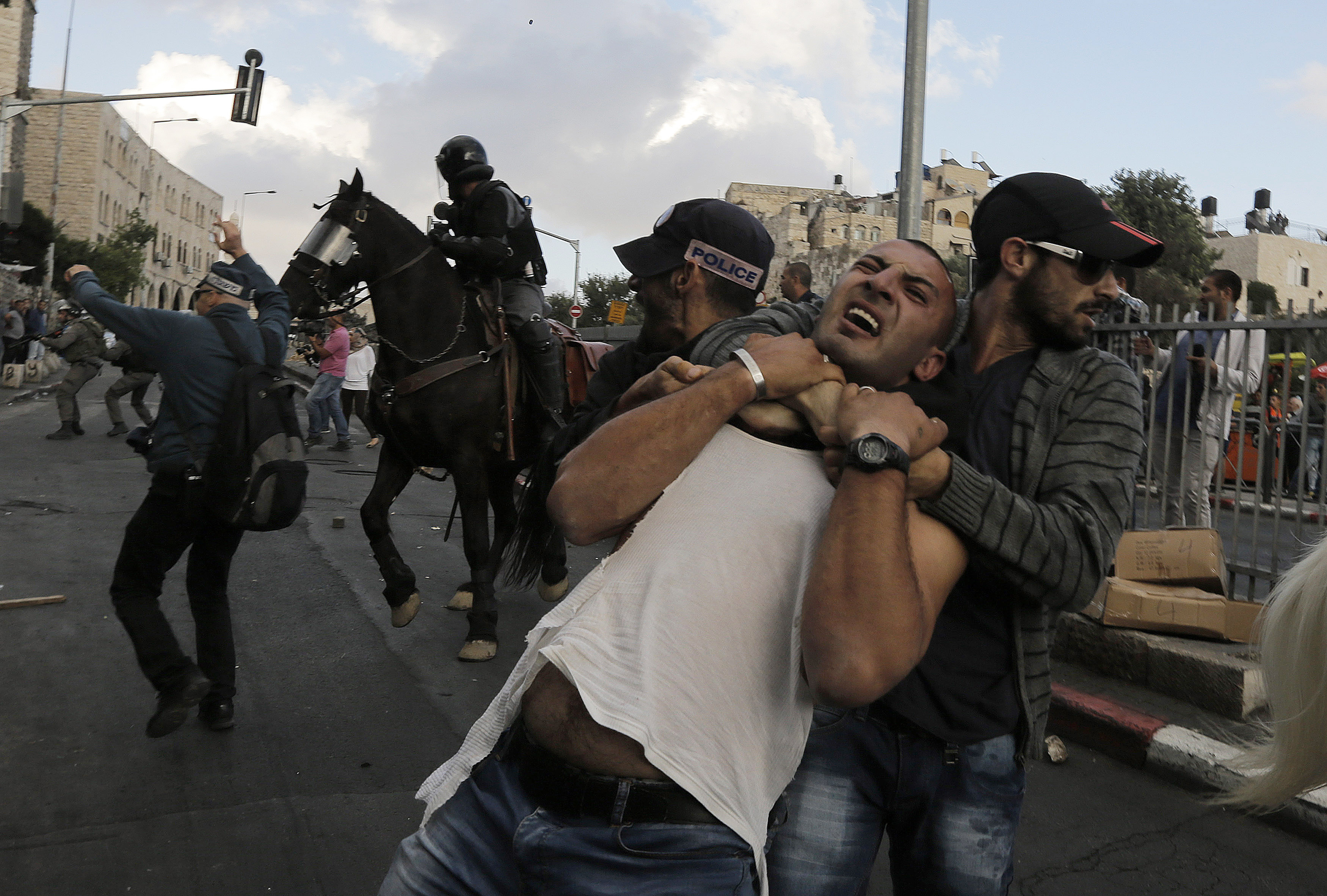 شرطي اسرائيلي بملابس مدنية يعتقل أحد المتظاهرين الفلسطينيين خلال اشتباكات في مظاهرة بالقرب من بوابة دمشق في مدينة القدس القديمة في 24 سبتمبر 2013