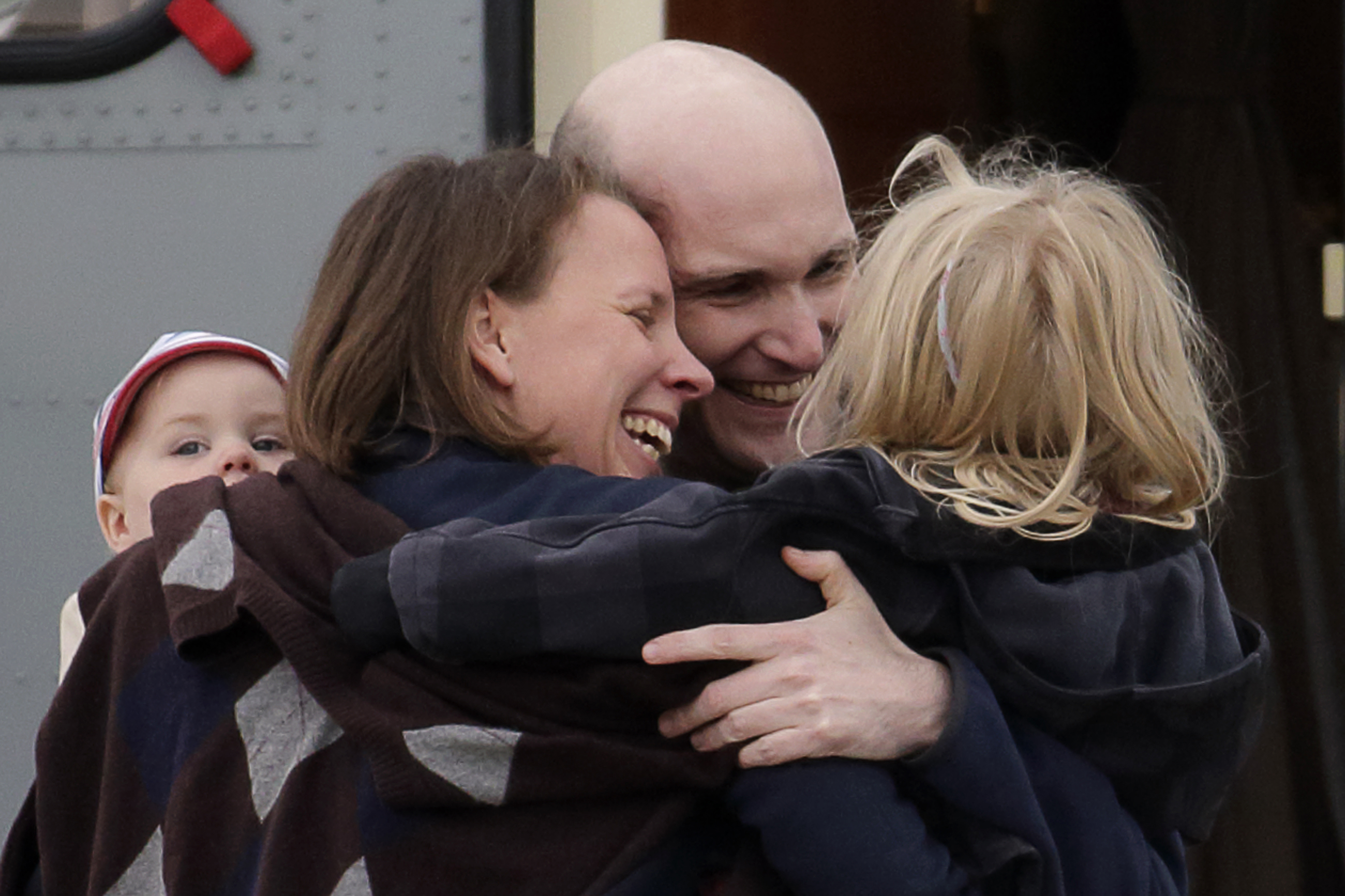 French journalist Nicolas Henin (C), former hostage, is greeted by his family moments after the arrival of the four former hostages by helicopter from Evreux to the military airbase near Paris on 20 April 2014